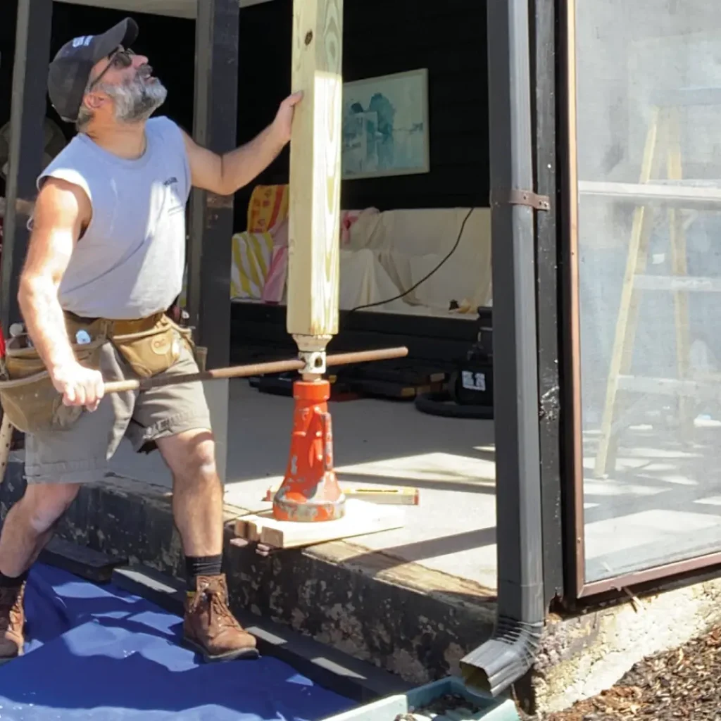 a person holding a pole of a porch