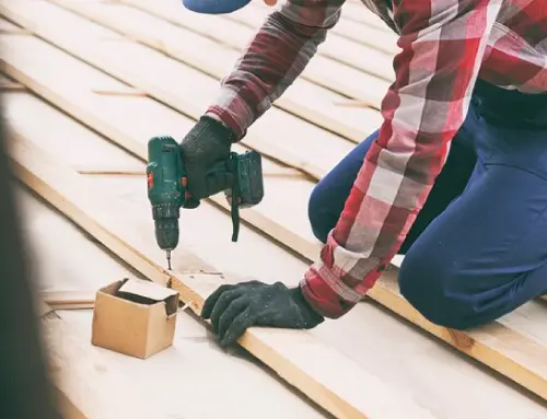 a person drilling wood by using drill to install a deck