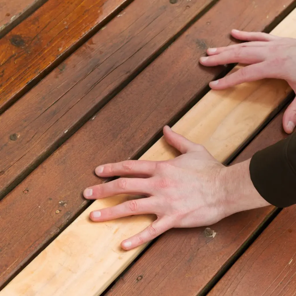 a person fixing a wooden deck