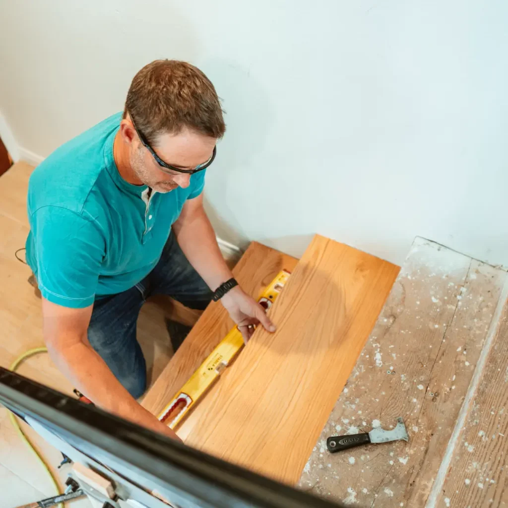 a person using a level to install hardwood stairs