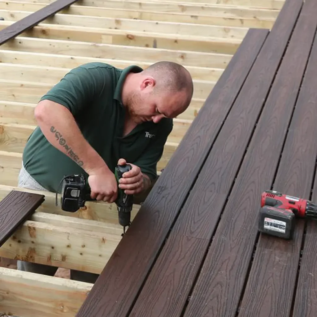 a person holding a drill to install a deck